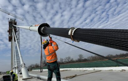 Stavba největšího lanového mostu v Česku je v plném proudu. Stavbaři instalují předposlední závěs